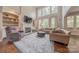 Bright living room featuring a cozy fireplace, built-in shelving, and a large sectional sofa at 3304 Danhill Pl, Matthews, NC 28105