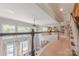 Open loft area with railing, pool view, abundant natural light and staircase access to other floors at 3304 Danhill Pl, Matthews, NC 28105