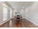A well-lit home office with hardwood floors, neutral walls, and a sleek modern desk at 3304 Danhill Pl, Matthews, NC 28105