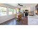 Eat-in kitchen with bright white cabinets, stainless appliances, mobile prep island, and large windows at 3307 Draper Ave, Charlotte, NC 28205