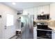 Bright kitchen featuring stainless steel appliances, white cabinetry and tile backsplash at 3307 Draper Ave, Charlotte, NC 28205