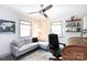Bright office with a gray sofa, ceiling fan, desk, and two windows at 3307 Draper Ave, Charlotte, NC 28205