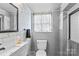 Well lit bathroom featuring a decorative mirror, patterned wallpaper, and tile in the shower at 366 Faith Rd, Mooresville, NC 28115