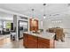 Spacious kitchen with a granite island, stainless steel refrigerator, wine rack, and open layout to the dining area at 366 Faith Rd, Mooresville, NC 28115