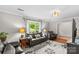Cozy living room with plush leather seating, a floral rug, a bay window, and natural light at 366 Faith Rd, Mooresville, NC 28115