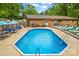 Sparkling in-ground pool surrounded by lounge chairs, umbrellas, and patio furniture for outdoor relaxation at 366 Faith Rd, Mooresville, NC 28115