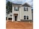 New two-story home featuring gray siding, stone accents, dark shutters, and a welcoming front entrance at 4017 Grommet Ct, Matthews, NC 28105