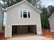 Detached two-car garage with gray siding, a large window and ample space for parking and storage at 4017 Grommet Ct, Matthews, NC 28105