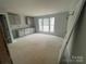 Spacious room showcasing potential with cabinet and natural light from windows at 4017 Grommet Ct, Matthews, NC 28105