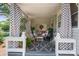 Relaxing covered porch featuring decorative curtains, string lights, and comfortable seating creating an inviting outdoor space at 404 N Laurel St, Lincolnton, NC 28092