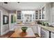 Bright kitchen with white cabinetry, granite countertops, stainless steel appliances and a butcher block island table at 404 N Laurel St, Lincolnton, NC 28092