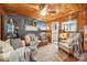 Living room with rustic wood paneling, ceiling fan, and comfortable leather sofa at 404 N Laurel St, Lincolnton, NC 28092