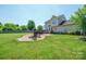 Spacious backyard with well-maintained lawn, a fire pit area, and a beautiful home exterior at 4301 Windjammer Sw Ct, Concord, NC 28027