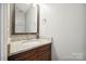 Bathroom vanity featuring granite countertops, wood cabinets and a framed mirror at 4301 Windjammer Sw Ct, Concord, NC 28027
