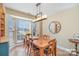 Dining area with a large window, wooden table, chairs and modern chandelier at 4301 Windjammer Sw Ct, Concord, NC 28027