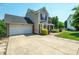 View of the house with a well-maintained two-car garage and concrete driveway, with manicured lawn at 4301 Windjammer Sw Ct, Concord, NC 28027