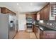 Traditional kitchen featuring wood cabinets, stainless steel appliances, and sleek backsplash at 4301 Windjammer Sw Ct, Concord, NC 28027