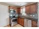 Cozy kitchen with stainless steel appliances, dark wood cabinets, and mosaic tile backsplash at 4301 Windjammer Sw Ct, Concord, NC 28027