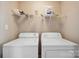 Bright laundry room features a washer, dryer, and convenient overhead storage shelf at 4301 Windjammer Sw Ct, Concord, NC 28027