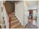 Carpeted staircase with wood railing leading upstairs, adjacent to the kitchen and an entry door at 4301 Windjammer Sw Ct, Concord, NC 28027