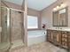 A bathroom featuring tile floors, tub, shower with glass door, and vanity with granite counters at 4562 Lanstone Sw Ct, Concord, NC 28027