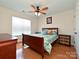 Comfortable bedroom with hardwood floors, ceiling fan, a window providing natural light, and dresser at 4562 Lanstone Sw Ct, Concord, NC 28027