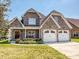 Charming brick home with a two-car garage and a well-manicured lawn on a sunny day at 4562 Lanstone Sw Ct, Concord, NC 28027