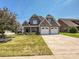 Beautiful home featuring a stone facade, three-car garage, and well-maintained landscaping at 4562 Lanstone Sw Ct, Concord, NC 28027