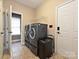 A laundry room with side-by-side washer and dryer, access to doors, and wire shelf at 4562 Lanstone Sw Ct, Concord, NC 28027
