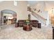 Open-concept living room with high ceilings, a staircase, and comfortable leather seating at 4562 Lanstone Sw Ct, Concord, NC 28027