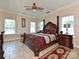 A traditional main bedroom featuring a four-poster bed, accent rug and two windows at 4562 Lanstone Sw Ct, Concord, NC 28027