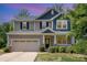 Charming two-story home with a large front yard, covered porch, and attached two-car garage at 5065 Watersail Way, Clover, SC 29710