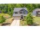 A picturesque two-story home with a manicured lawn, quaint front porch, and a two-car attached garage at 5065 Watersail Way, Clover, SC 29710