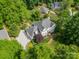 Aerial view of a beautiful home with a landscaped yard, long driveway, and mature trees at 5135 Winding Brook Rd, Charlotte, NC 28226