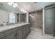 Modern bathroom with a double sink vanity, granite countertop, and glass enclosed shower with built in seat at 5135 Winding Brook Rd, Charlotte, NC 28226