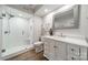 Contemporary bathroom with a glass enclosed shower, vanity, wood look floors and a framed mirror at 5135 Winding Brook Rd, Charlotte, NC 28226
