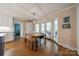 Charming dining area with wood floors and a light fixture next to the windows and white cabinets at 5135 Winding Brook Rd, Charlotte, NC 28226