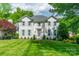 Charming two-story white brick home with lush lawn and manicured landscaping at 5135 Winding Brook Rd, Charlotte, NC 28226
