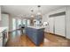 Bright open kitchen featuring a blue island, white cabinetry, and view to the dining area at 5135 Winding Brook Rd, Charlotte, NC 28226