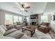 Bright living room with a fireplace, large windows, ceiling fan, hardwood floors and stylish furnishings at 5135 Winding Brook Rd, Charlotte, NC 28226