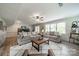 Cozy living room with neutral tones, large windows, hardwood floors, ceiling fan and comfortable seating at 5135 Winding Brook Rd, Charlotte, NC 28226