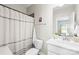 Well-lit bathroom features a shower with stylish striped curtain and modern sink at 5648 Woodard St, Charlotte, NC 28269