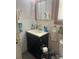 Compact bathroom features a black vanity with sink and an mirrored medicine cabinet at 621 Benton St, Monroe, NC 28110