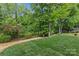 Green backyard with a fence and lush trees, plants, and shrubs at 624 Heather Ln, Charlotte, NC 28209
