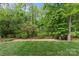 Lush green backyard bordered by mulch and a fence, with a line running through the grass at 624 Heather Ln, Charlotte, NC 28209
