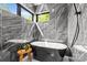 Modern bathroom features a freestanding soaking tub, black marble tiling, and a sunlit window at 624 Heather Ln, Charlotte, NC 28209