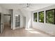Bright bedroom with a doorway to a bathroom, hardwood floors, and three large windows at 624 Heather Ln, Charlotte, NC 28209