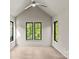 Bright bedroom featuring vaulted ceiling, hardwood floors, and three large windows at 624 Heather Ln, Charlotte, NC 28209