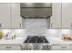 Close-up of a modern kitchen featuring stainless steel appliances and marble backsplash at 624 Heather Ln, Charlotte, NC 28209