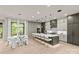 Bright eat-in kitchen featuring a long island with seating and stainless appliances with hardwood floors and modern lighting at 624 Heather Ln, Charlotte, NC 28209